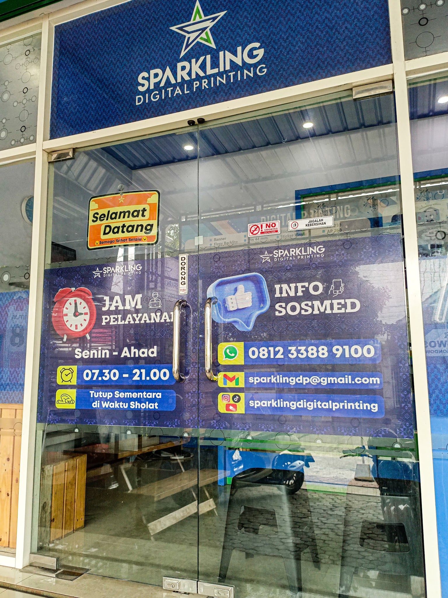 Pintu kaca toko Sparkling dengan jam layanan dan kontak